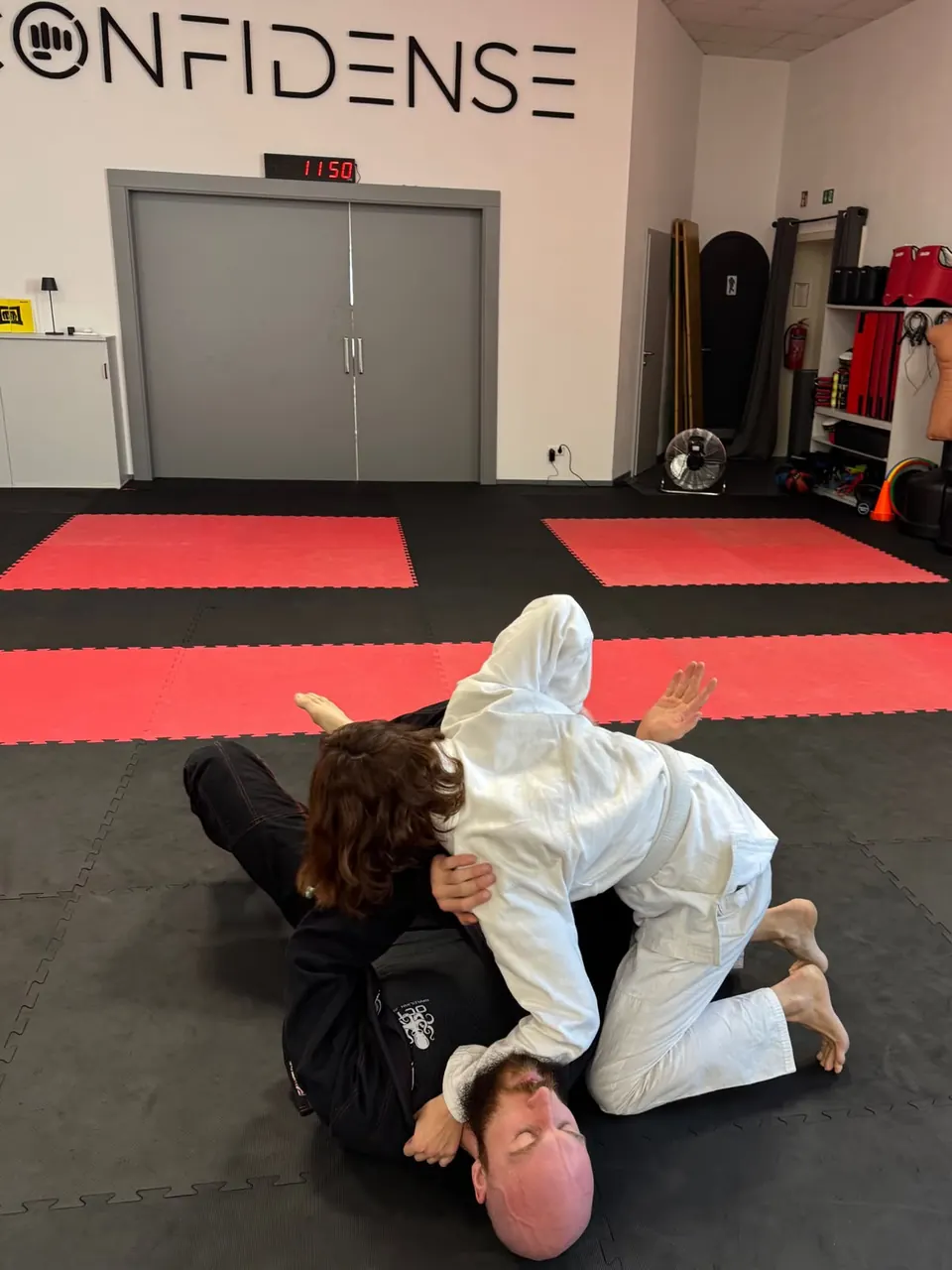 Zwei Trainierende üben gemeinsam eine Position im Brazilian Jiu-Jitsu auf der CONFIDENSE-Matte