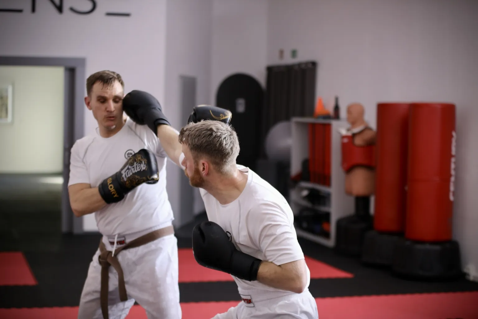 Zwei Erwachsene trainieren mit Boxhandschuhen im CONFIDENSE-Studio.